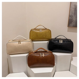 Close-up of portable travel bags in four colors with crocodile texture and metal zippers