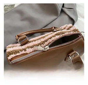Detail of silver metal zipper and pink plush striped texture on brown leather bag