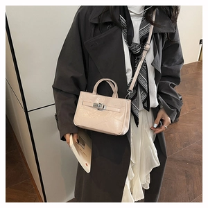 Détail du sac seau beige de luxe avec cuir verni brillant et fermoir en métal argenté