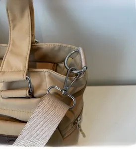 Détail du fermoir mousqueton en métal argenté et de l'anneau en D sur le sac fourre-tout