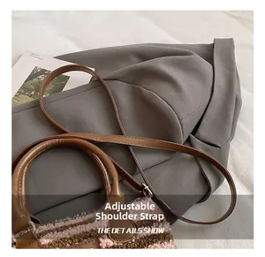 Detail showing the adjustable leather shoulder strap and plush striped texture of the bag
