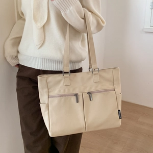 Detail view of large canvas tote bag with functional double front zipper pockets