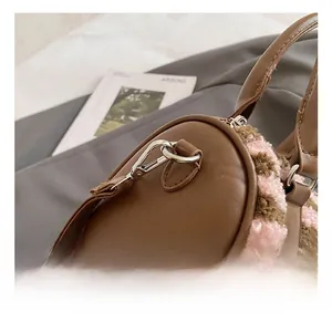 Detail of silver metal hook and D-ring on striped plush pillow bag with leather strap