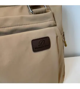 Gros plan du sac fourre-tout en nylon kaki montrant les coutures et l'écusson logo