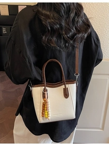 Retro cream and brown contrast mini tote bag with beaded charm accessory shown on model