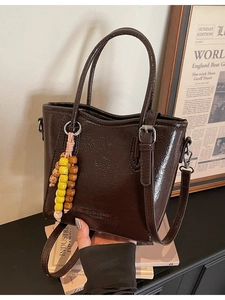 Vintage dark brown glossy leather bucket bag with top handle and beaded tassel charm