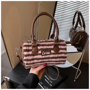 Detail of plush boston bag with pink and brown striped faux fur and leather handle