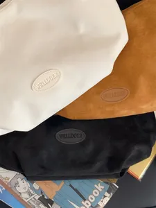 Detailed close-up of suede multifunctional tote bags in white, caramel, and black colors