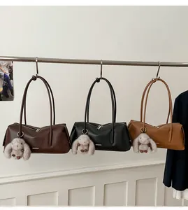 Detailansicht der Schultertaschen in Braun, Schwarz und Hellbraun mit Plüsch-Anhängern