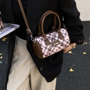 Detail of a pink boston bag with retro check pattern and Love script text on the front