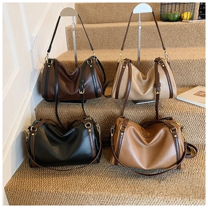 Detailed view of four vintage Boston bags in brown, beige, and black on a display shelf
