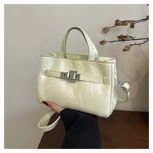 Détail du sac seau de luxe jaune clair avec cuir plissé brillant et boucle en métal
