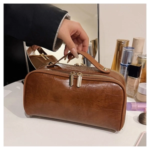 Detail of dark brown crocodile texture travel storage bag with double zipper design