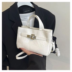 Vue détaillée du sac seau blanc cassé avec texture cuir et fermoir rotatif argenté