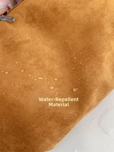 Macro detail of brown water-repellent matte leather fabric with clear water droplets