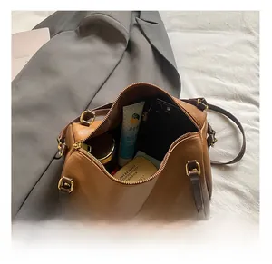 Interior view showing the large capacity of a retro brown Boston bag with daily essentials