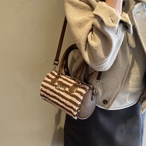 Detail of plush striped cylinder bag showing Love print and brown faux leather strap