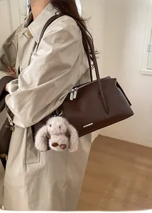 Detail der dunkelbraunen Leder-Tote-Bag mit Silberreißverschluss und Hasenanhänger