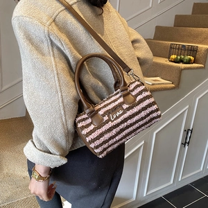 Close-up of fluffy striped pillow bag featuring pink brown fur and Love patch detail