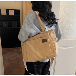 Detail view of khaki large tote bag featuring durable nylon fabric and functional side zipper