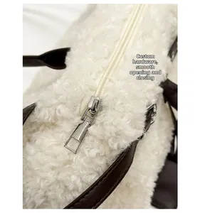 Detail of silver zipper closure on beige faux shearling tote with brown leather handle