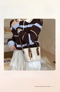 Sac seau rétro crème avec bordure en cuir marron, bandoulière et breloque perlée