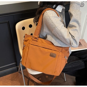 Detail of orange waterproof nylon tote with multiple pockets and adjustable shoulder strap