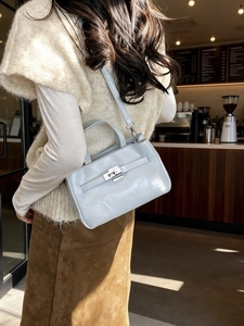 Sac seau en cuir bleu clair brillant avec fermoir argenté et bandoulière réglable