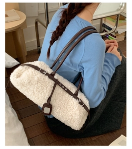 Detail of white faux shearling tote bag with premium brown leather straps and silver buckles