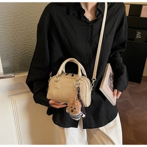 Beige Boston handbag with detachable shoulder strap shown in a minimal lifestyle setting