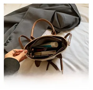 Interior view of small bicolor bucket bag with cosmetics showing storage capacity