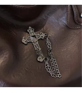 Macro shot of retro silver cross pendant with baroque relief and double metal chains