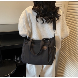 Grand sac cabas en nylon noir avec bandoulière réglable et étiquette en cuir