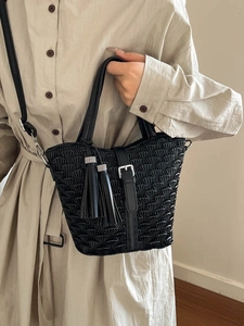 Fashionable black woven bucket bag with tassels and metallic buckle for women