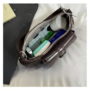 Top view of deep brown patent leather bag interior showing large capacity and zipper pocket