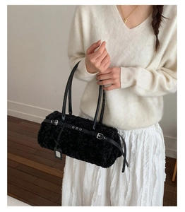 Detail of black faux shearling tote bag featuring leather strap and plush texture