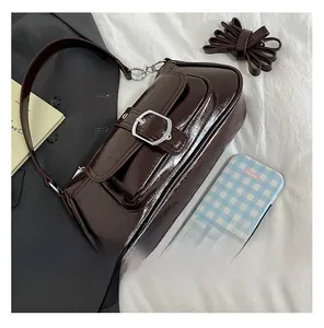 Detailed macro of coffee brown glossy faux leather baguette bag with silver metal buckle