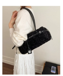Close-up of a black faux lamb fur tote bag on model showing soft plush texture