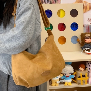 Close-up of caramel hobo bag featuring matte faux suede texture and leather brand tag