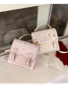 Close-up of pink and cream cartoon bear handbag with cute prints and gold logo details