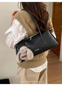 Detail der schwarzen Retro Boston Pillow Bag mit Plüschhasen-Anhänger und Logo-Plakette