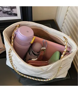 Spacious interior of white quilted tote bag holding a tablet, umbrella, and daily items