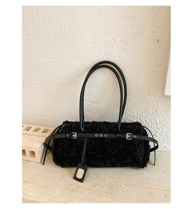 Detail of black faux fur shoulder bag with leather straps and silver buckle accents
