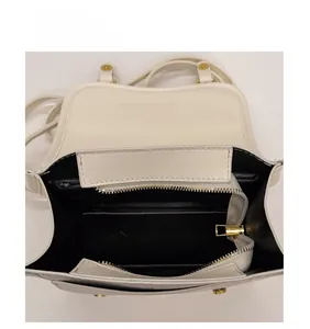 Internal view showing the spacious black lining and layered structure of the cream handbag