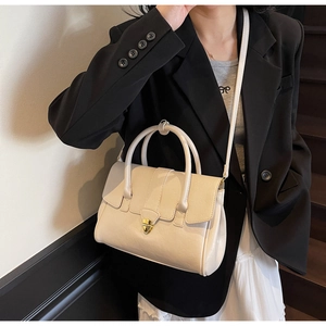 Chic cream leather handbag with heart-shaped gold lock shown on model for daily styling