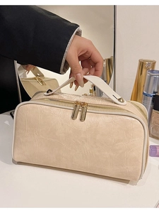 Creamy beige faux crocodile leather cosmetic bag with gold zippers and sturdy top handle