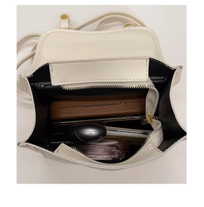 Top view of cream white shoulder bag interior showing storage for phone and daily items