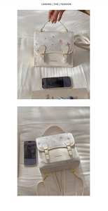 Detail view of white cartoon bear backpack with textured faux leather and bow pattern