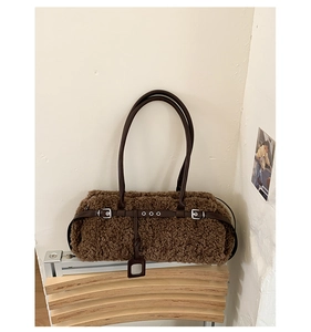 Detail of brown faux shearling tote bag with dark leather straps and silver metal eyelets