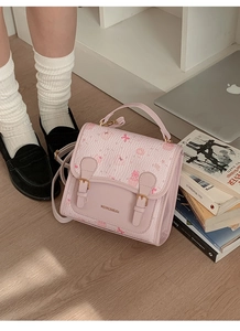 Detail of cute cartoon bear pattern on pink PU leather satchel bag with retro school vibes